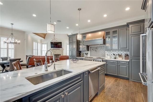 kitchen with decorative light fixtures, custom range hood, sink, and gray cabinetry