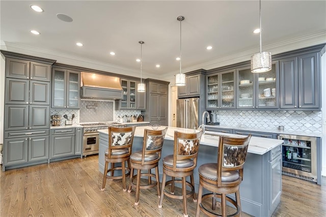 kitchen with pendant lighting, wine cooler, premium range hood, and a kitchen island