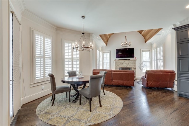 dining room with dark wood-type flooring, lofted ceiling, a wealth of natural light, and a fireplace