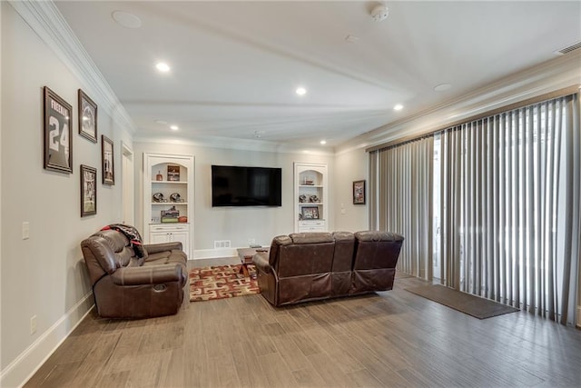 living room featuring crown molding, hardwood / wood-style floors, and built in shelves