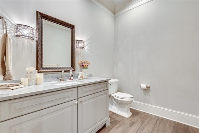 bathroom with vanity, hardwood / wood-style floors, ornamental molding, and toilet