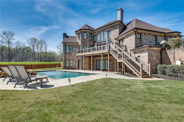 rear view of property featuring a patio area and a lawn