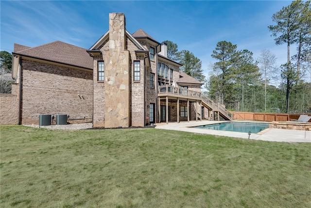 back of house with a patio, central AC, a swimming pool side deck, and a lawn