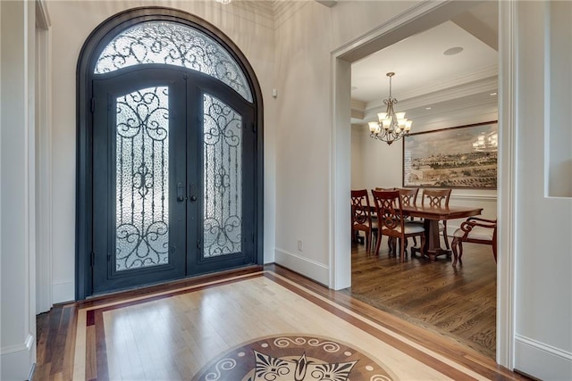 entrance foyer featuring french doors, hardwood / wood-style flooring, and a chandelier