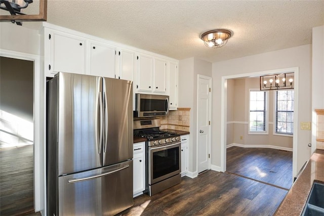 kitchen with a textured ceiling, decorative backsplash, dark hardwood / wood-style flooring, white cabinets, and appliances with stainless steel finishes