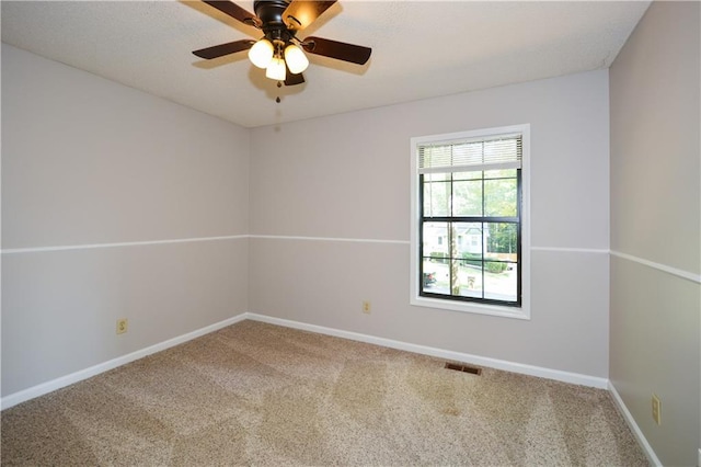 carpeted spare room featuring ceiling fan