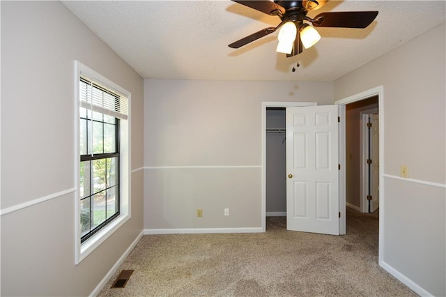 unfurnished bedroom featuring ceiling fan, light carpet, and multiple windows