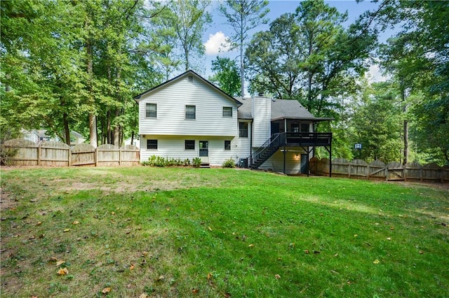 rear view of house with a yard and a wooden deck