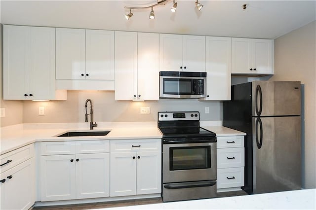 kitchen with sink, stainless steel appliances, and white cabinets