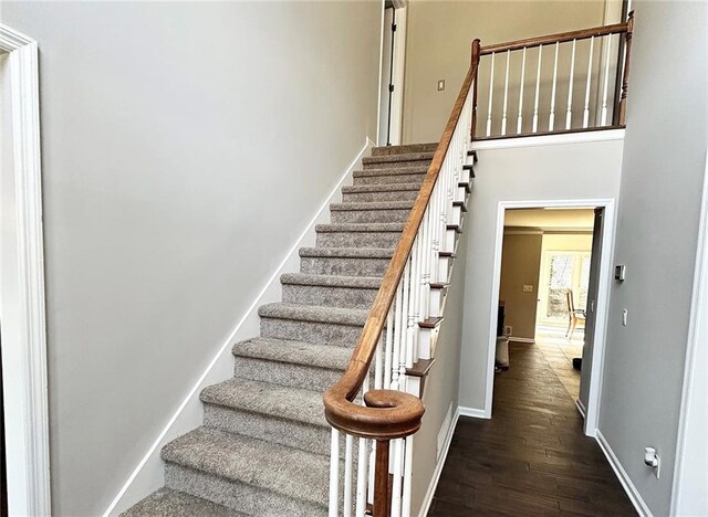 stairway featuring wood-type flooring and ornamental molding