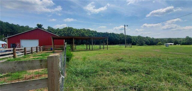 2268 Horse Farm Rd, Dewy Rose, GA 30634 - view of yard featuring an outbuilding, a detached garage, fence, a pole building, and a rural view