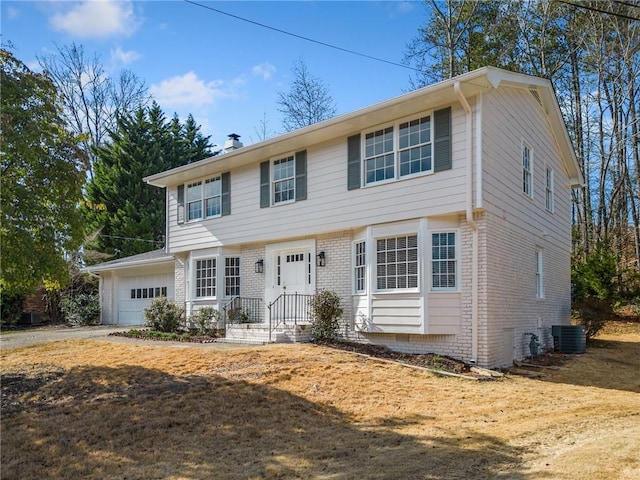 colonial house with central AC unit and a garage