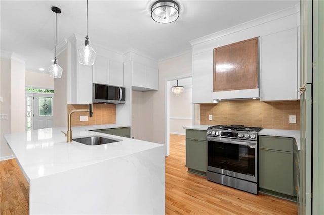 184 Corner Oak Ct, Waleska, GA 30183 - kitchen with stainless steel range with gas cooktop, ornamental molding, green cabinets, tasteful backsplash, and a peninsula