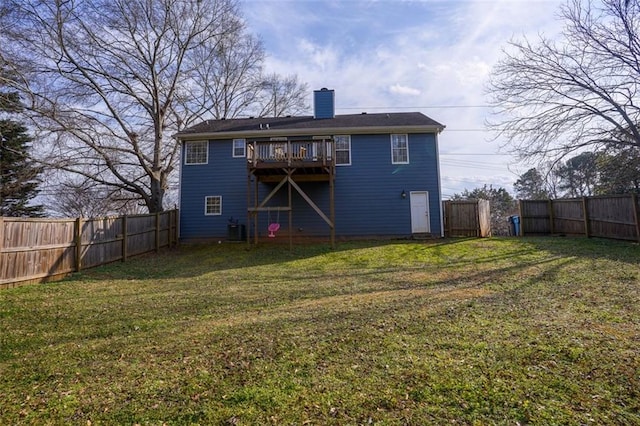 rear view of house with central air condition unit, a lawn, a chimney, and a fenced backyard