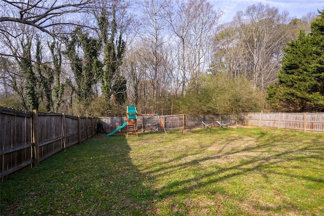 view of yard with a fenced backyard and a playground