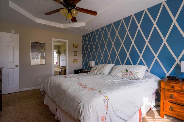 carpeted bedroom with a tray ceiling, a textured ceiling, wallpapered walls, baseboards, and an accent wall