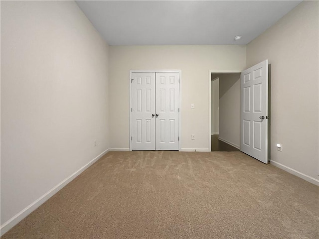 unfurnished bedroom with carpet floors, baseboards, and a closet