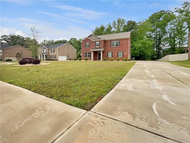 colonial inspired home with brick siding, fence, and a front lawn