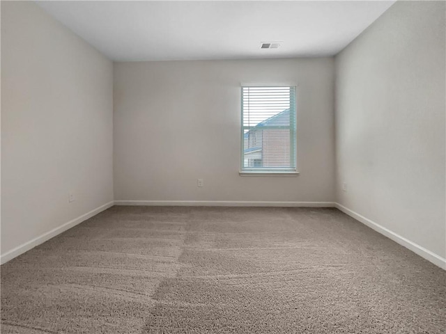 unfurnished room with baseboards, carpet flooring, and visible vents