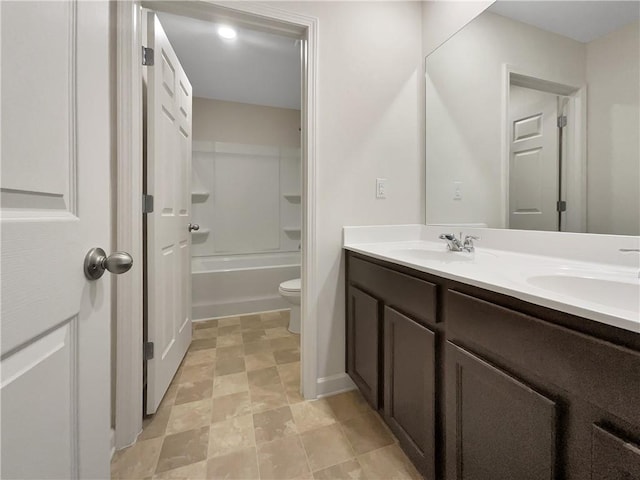 bathroom with a sink, toilet, double vanity, and  shower combination