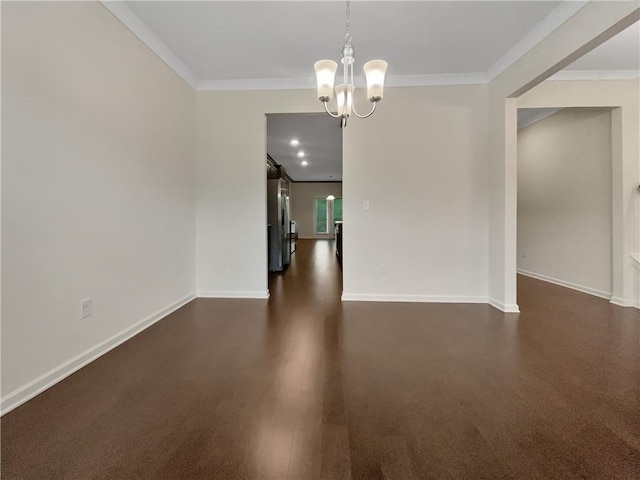 empty room with baseboards, a chandelier, and ornamental molding