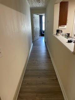 hall with dark wood-style floors and baseboards