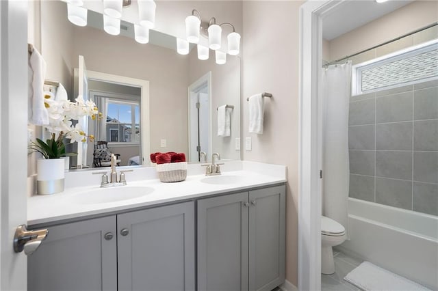 bathroom with double vanity, toilet, shower / tub combo, and a sink