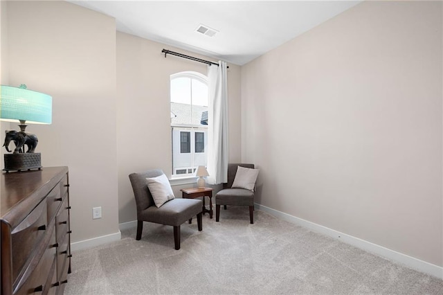 sitting room featuring baseboards, light carpet, and visible vents