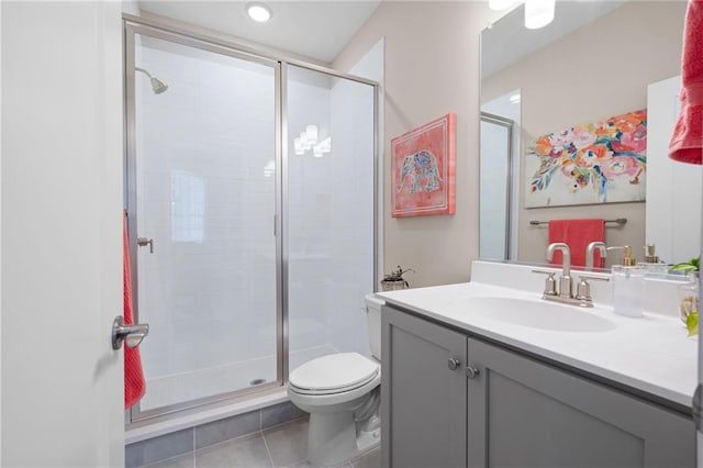 bathroom featuring tile patterned floors, toilet, a stall shower, and vanity