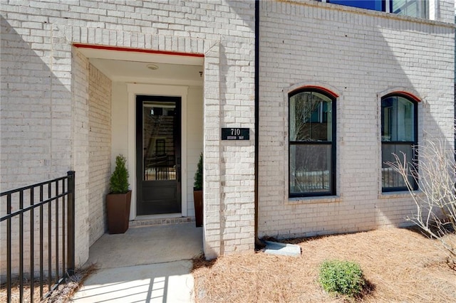 doorway to property featuring brick siding