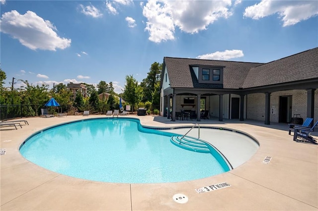 community pool with a patio and fence