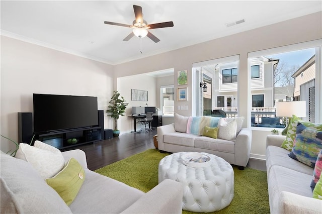 living area featuring visible vents, crown molding, a ceiling fan, and wood finished floors