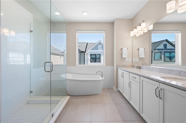 full bathroom featuring a sink, double vanity, a shower stall, and tile patterned floors