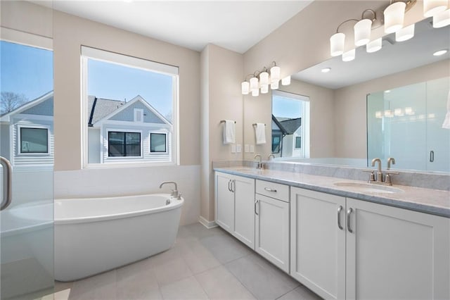 full bathroom with a sink, a soaking tub, a stall shower, and double vanity