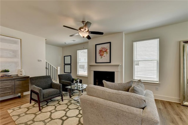 living room featuring ceiling fan and light hardwood / wood-style floors