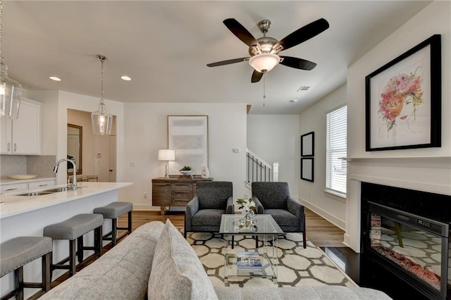 living room featuring sink, ceiling fan, and dark wood-type flooring