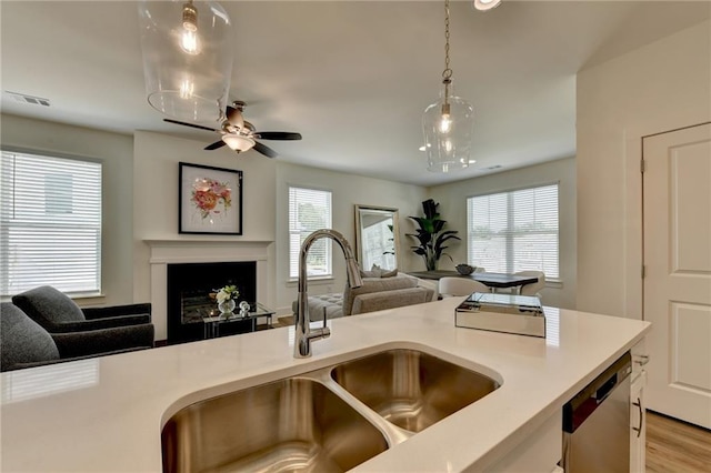 kitchen featuring sink, dishwasher, ceiling fan, light wood-type flooring, and pendant lighting