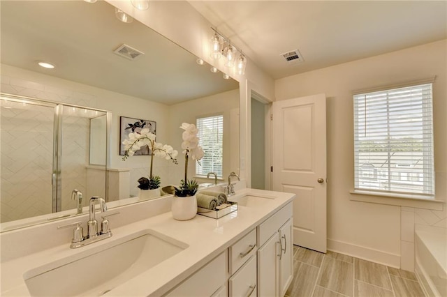 bathroom featuring a shower with door and vanity