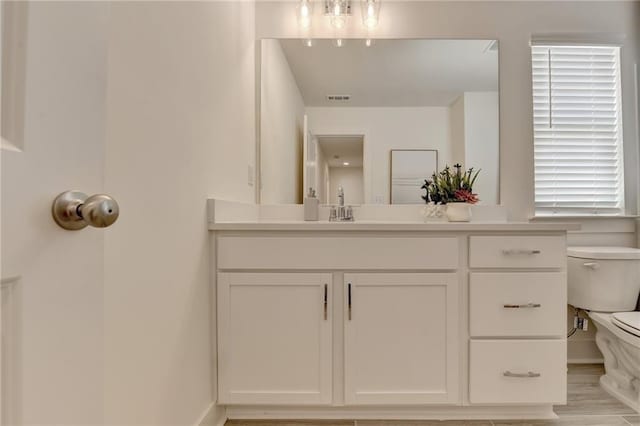 bathroom featuring toilet, hardwood / wood-style floors, and vanity