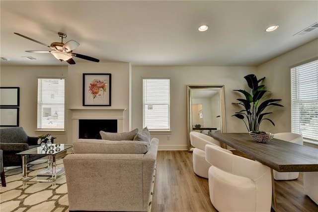 living room featuring light wood-type flooring and ceiling fan