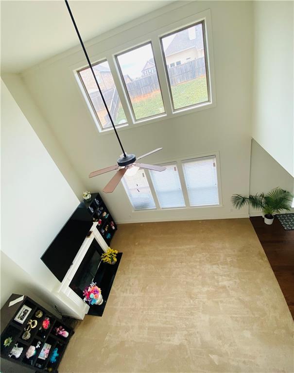 interior space with a ceiling fan and a towering ceiling