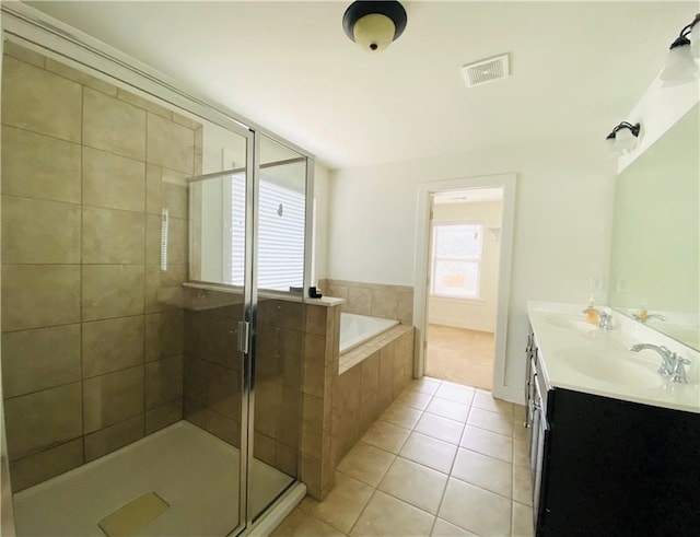 full bath featuring a stall shower, tile patterned flooring, a sink, and a bath