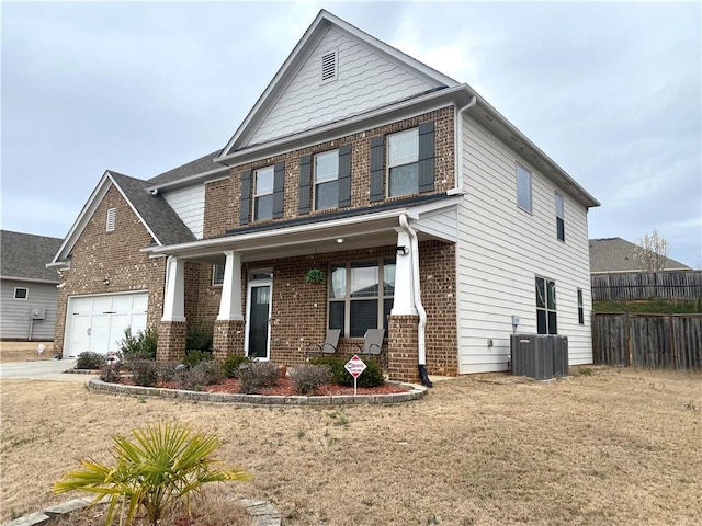 view of front of house featuring a garage, driveway, central AC unit, fence, and brick siding