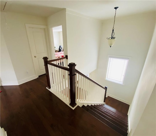 stairs featuring wood finished floors, attic access, and baseboards