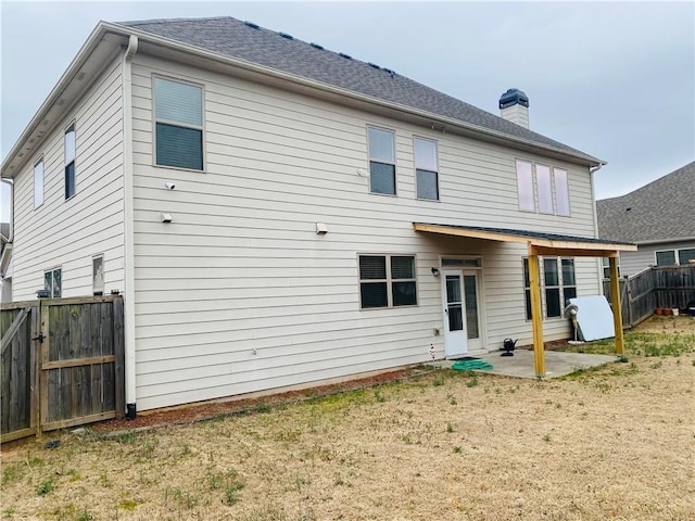 back of house featuring a chimney, a patio area, and fence