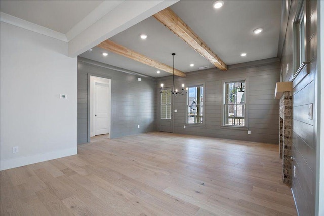 empty room with a notable chandelier, recessed lighting, light wood-style flooring, beamed ceiling, and baseboards