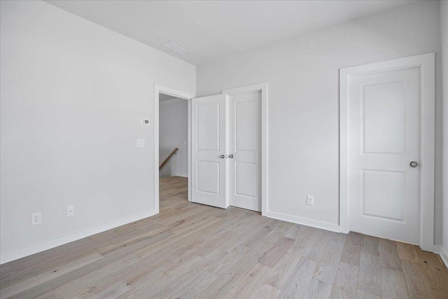 unfurnished bedroom featuring light wood finished floors and baseboards