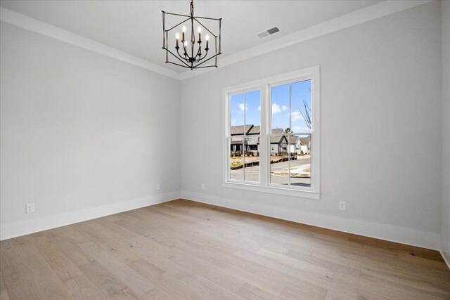 unfurnished dining area featuring ornamental molding, visible vents, baseboards, and wood finished floors