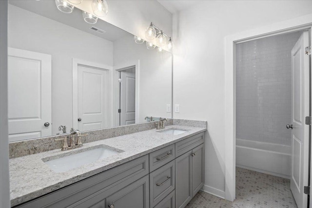 full bath featuring double vanity, a sink, visible vents, and baseboards