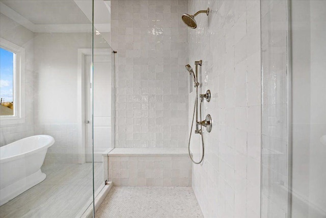 bathroom with a stall shower, a freestanding bath, and tile walls